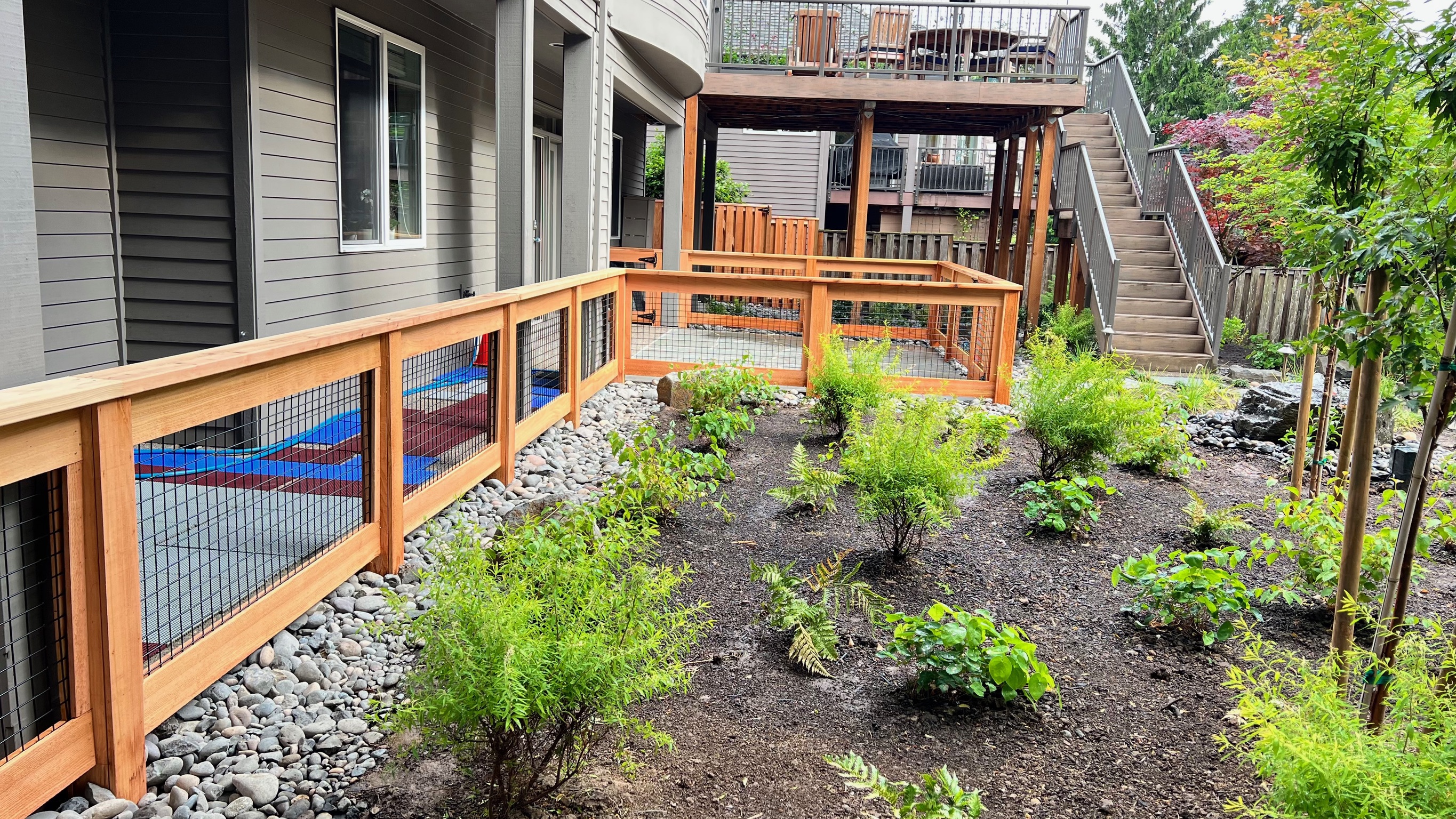 Finished cedar and hog-wire fence integrated into a landscaped backyard