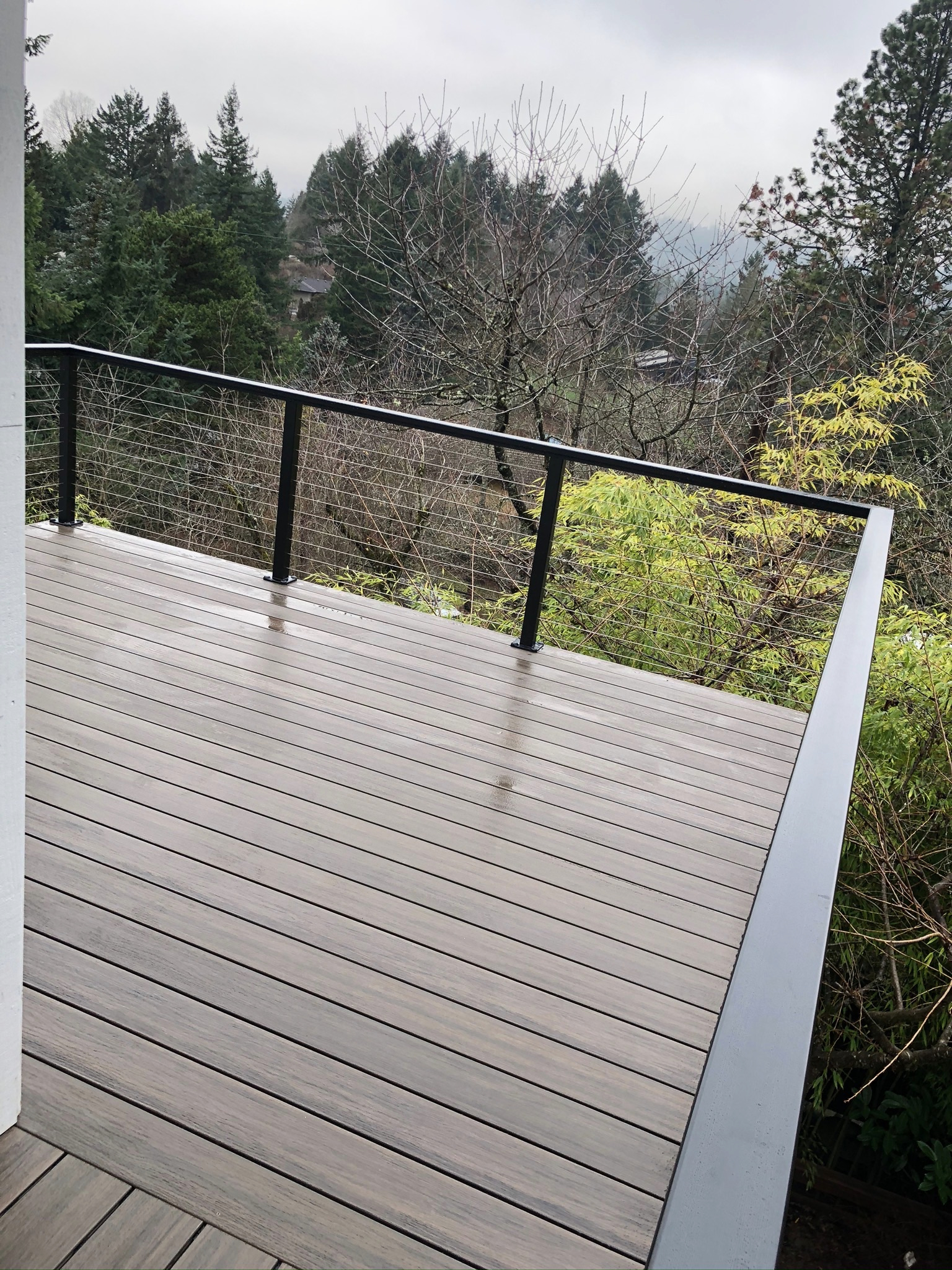 Composite hillside deck with black cable railing