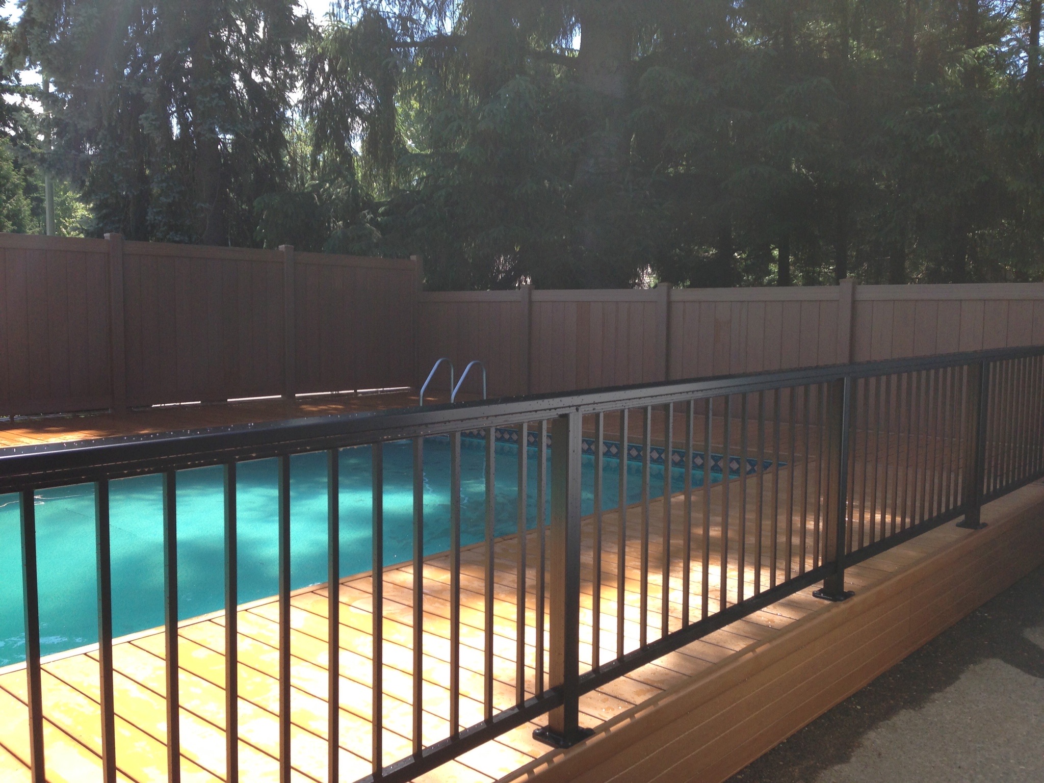 The finished pool deck with black railing